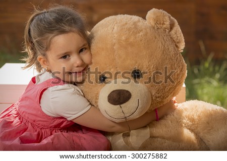 girl hugging huge teddy bear