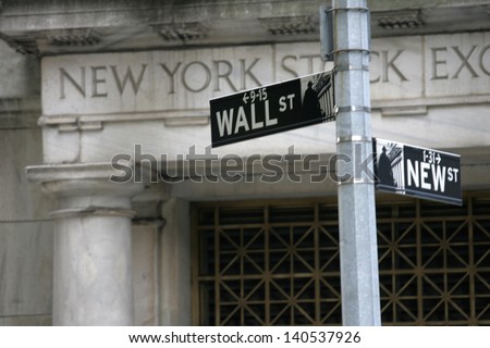 NEW YORK - MAY 30: A Wall Street street sign is shown on May 30, 2013 in New York City. The Exchange building was built in 1903. - stock photo