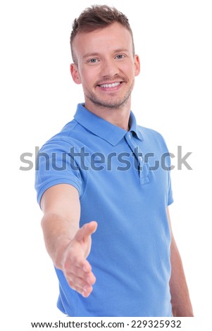 picture of a young casual man offering a friendly handshake while smiling for the camera. isolated on a white background - stock photo