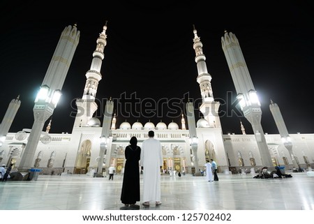 MEDINA - JULY 21 : A couple is standing in the front of holy mosque on July 21, 2012 in Medina, Saudi Arabia.  Medina mosque is the second holiest and most visited mosque for all Muslims. - stock photo