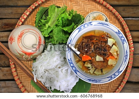 Bun Cha - Vietnamese cuisine: Grilled pork with tasty fish sauce, rice noodles and herbs on a bamboo tray