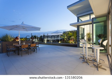 Modern balcony at sunset in luxury penthouse - stock photo