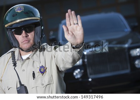 stock-photo-confident-middle-aged-traffic-cop-signaling-stop-gesture-with-car-in-background-149317496.jpg