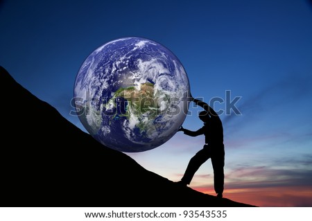 hard work.The person rolls the globe on mountain. - stock photo