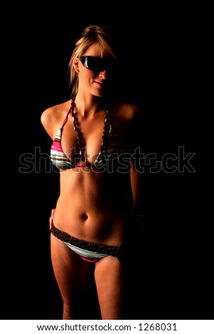 young sexy girl wearing her sunglasses posing in beach bikini on black 