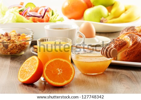 Breakfast including coffee, bread, honey, orange juice, muesli and fruits - stock photo