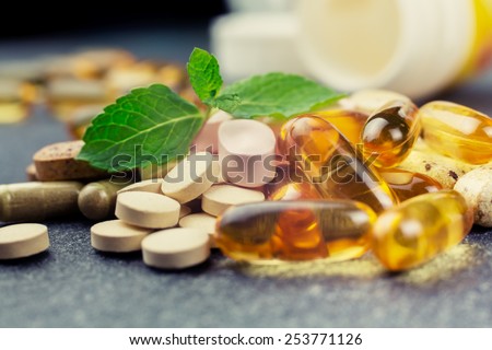 pills and multivitamins on a dark background, closeup - stock photo