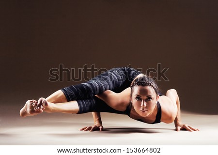 hard is sporty out. working  angle poses  woman Beautiful Eight yoga Astavakrasana pose,