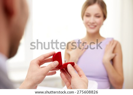 Woman gives engagement ring to couple