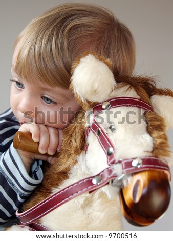 tired boy after long ride on rocking horse - stock photo - stock-photo-tired-boy-after-long-ride-on-rocking-horse-9700516