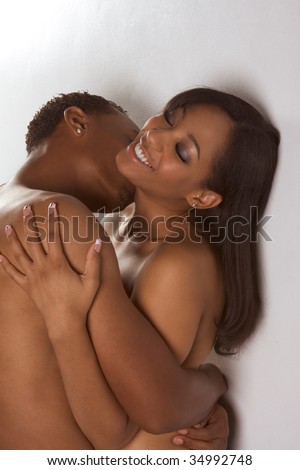 Loving ethnic black African-American young affectionate nude heterosexual couple in affectionate sensual kiss. - stock photo