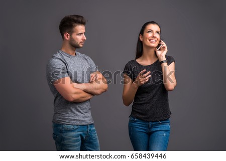 http://thumb9.shutterstock.com/display_pic_with_logo/74301/658439446/stock-photo-a-beautiful-young-woman-standing-and-talking-on-her-phone-and-ignoring-her-handsome-boyfriend-658439446.jpg