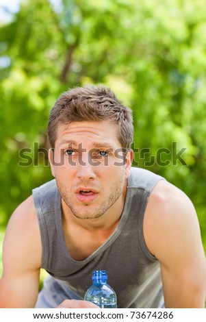 Sporty man drinking water in the park - stock photo - stock-photo-sporty-man-drinking-water-in-the-park-73674286