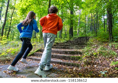 Healthy lifestyle - teenage girl and boy running, jumping outdoor ...