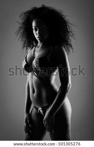 beautiful low key black and white portrait of beautiful black woman in lingerie - stock photo