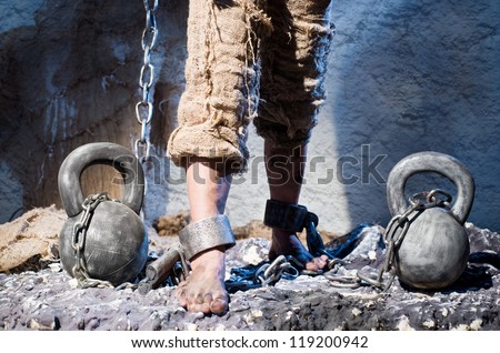 Legs in heavy iron shackles - stock photo