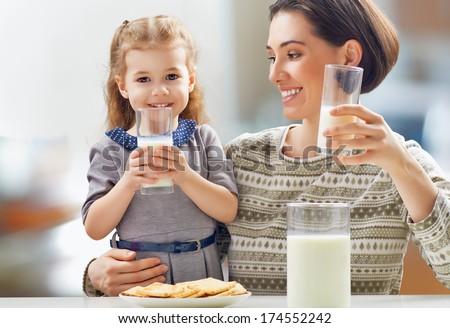 girl drinking milk at the kitchen - stock photo