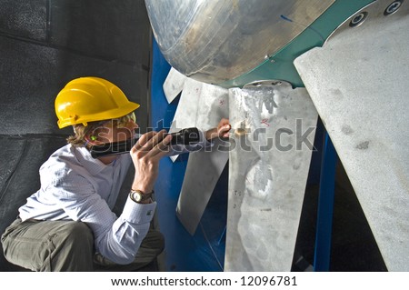 young engineer inspecting the blades of an industrial wind tunnel