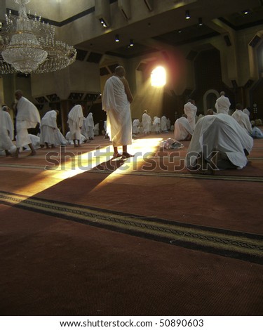 MECCA - DEC 11 : Muslim pilgrims in 'ihram' clothes pray at one of the mosques Dec 11, 2007 in Mecca. 'Ihram' clothes consist of two unhemmed white clothes intended to make everyone appear the same. - stock photo