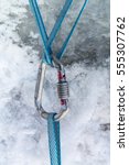 Small photo of Climbing harnesses blue cords are connected together using carabiner, against the background of snow and ice