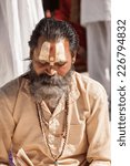 Small photo of GANGOTRI, INDIA - MAY 23rd - A Hindu priest sits in the temple courtyard to read Vedic scriptures in Gangotri on 23rd May 2013.