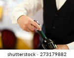 Small photo of Waiter uncorking a wine bottle in a restaurant