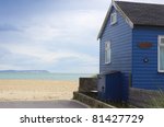 a blue wooden beach hut with a...