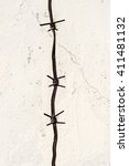 Small photo of Three barbs from a barbed wire fence set against a white brick wall painted background. Copy Space area for security or prison style ideas.