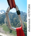 Small photo of View of the Caucasus Mountains through the climbing carabiner. Kabardino Balkariya, Russia.