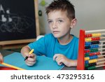 stock-photo-portrait-of-a-thinking-school-boy-working-on-math-homework-with-an-abacus-473295316.jpg