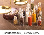 Small photo of Little bottles with spices and scales on the table, vedic cuisine