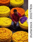 Small photo of BANGALORE, INDIA - June 06: Man selling ropes of flowers at KR Market in Bangalore. June 06, 2014 in Bangalore, India.