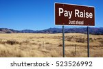 Small photo of Pay Raise road sign with blue sky and wilderness