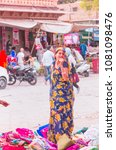 Small photo of JODHPUR, INDIA - MARCH 03, 2018: Unidentified woman sells Sari traditional costume at Sardar street market in Jodhpur.