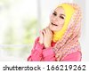 Fashion portrait of young happy beautiful muslim woman with pink costume wearing hijab - stock photo