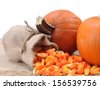 candy corn and pumpkin against white wall - stock photo