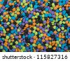 Background of colorful candy sprinkle toppings.  Round shapes in orange, black, purple, blue and green. - stock photo