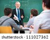 Teacher with a group of high school students in classroom - stock photo