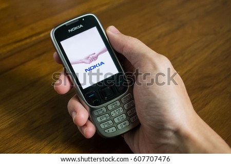 Bangkok, Thailand - March 24, 2017 : Nokia mobile phone held in one hand showing its screen with Nokia logo.