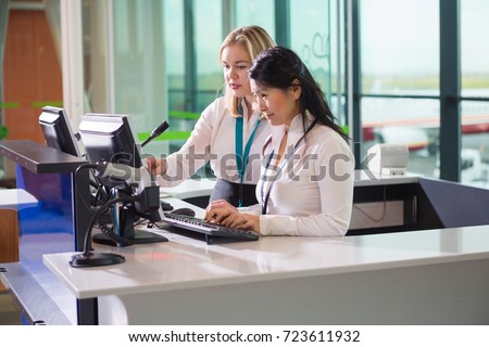 Female Ground Staff Using Computer At Counter In Airport