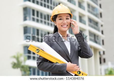 Female engineer consulting by phone right from the construction site