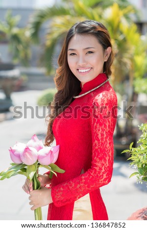 Vertical portrait of a young lady with lotus in hands