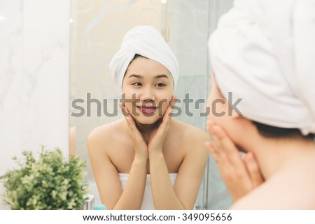 Attractive Asian girl enjoying soft skin of her face