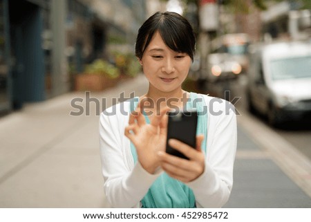 https://thumb9.shutterstock.com/display_pic_with_logo/1051921/452985472/stock-photo-young-asian-woman-walking-street-texting-cell-phone-452985472.jpg