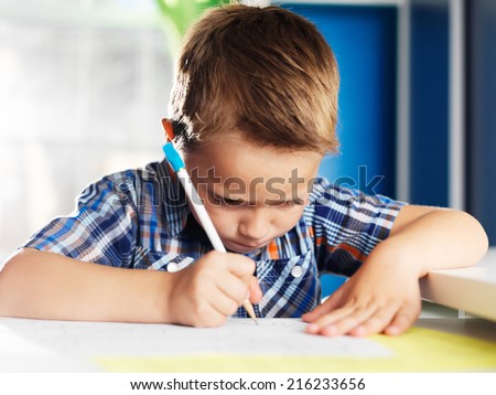 little boy working very hard on homework