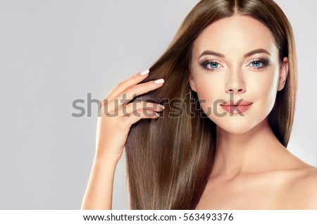 Beautiful model girl with shiny brown straight long hair . Care and hair products .