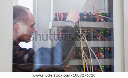 Electrician engineer tests electrical installations and wires on relay protection system. Bay control unit. Medium voltage switchgear