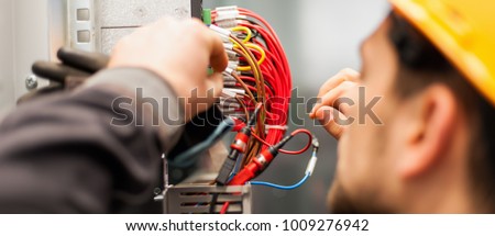 Electrician engineer tests electrical installations and wires on relay protection system. Bay control unit. Medium voltage switchgear