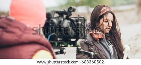 Behind the scene. Actress in front of the camera on the film set outdoor location. Group movie scene