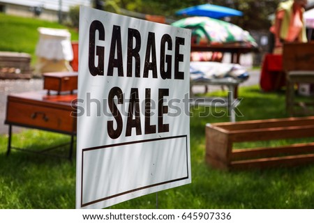 Garage Sale Sign On The Shady Lawn Of A Suburban Home Shallow Focus In Center Garage Sale Sign On The Shady Lawn Of A Suburban Home Shallow Focus In Center